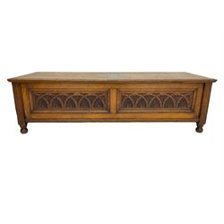 Early 20th century oak ‘bay window’ shaped blanket chest or coffer, hinged top, the front with two lunette carved panels flanked by fluted uprights, on turned feet