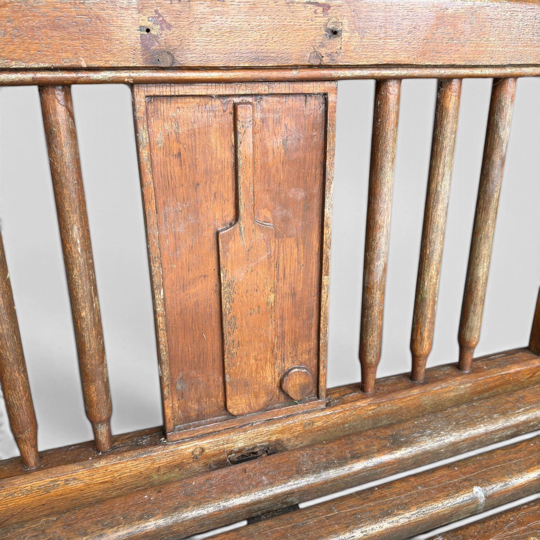 20th century teak cricket bench featuring a central splat with moulded cricket bat and ball motif flanked by stylised wicket spindles, over a slatted seat and square supports