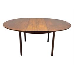 Mid-20th century teak extending dining table, circular top with pull-out extension and concealed leaf extension mechanism, on tapered supports; set of four teak dining chairs with black vinyl padded seats 