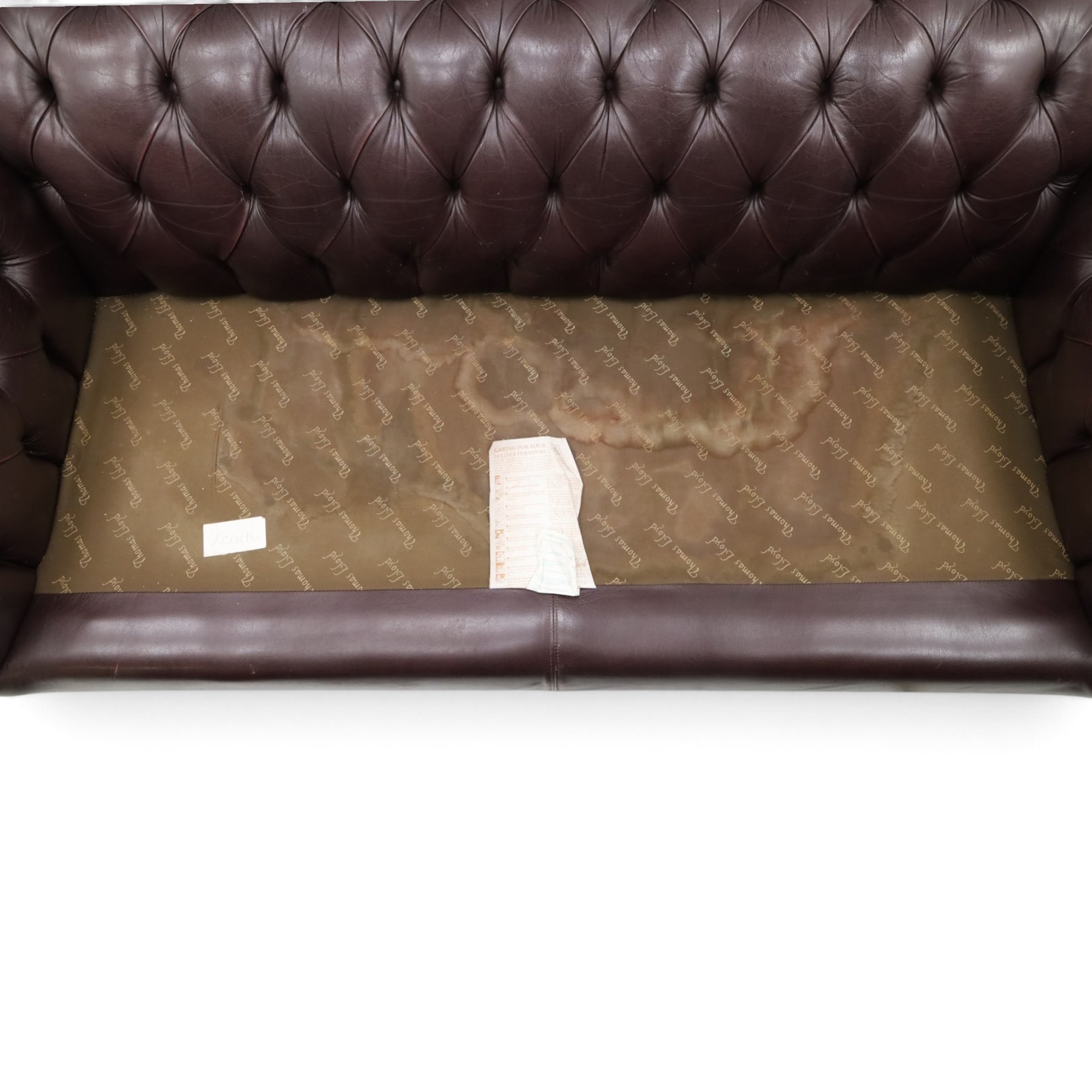 Thomas Lloyd - traditional shape Chesterfield two seater settee with rolled back and arms, upholstered in buttoned deep oxblood leather with loose seat cushions, raised on turned feet