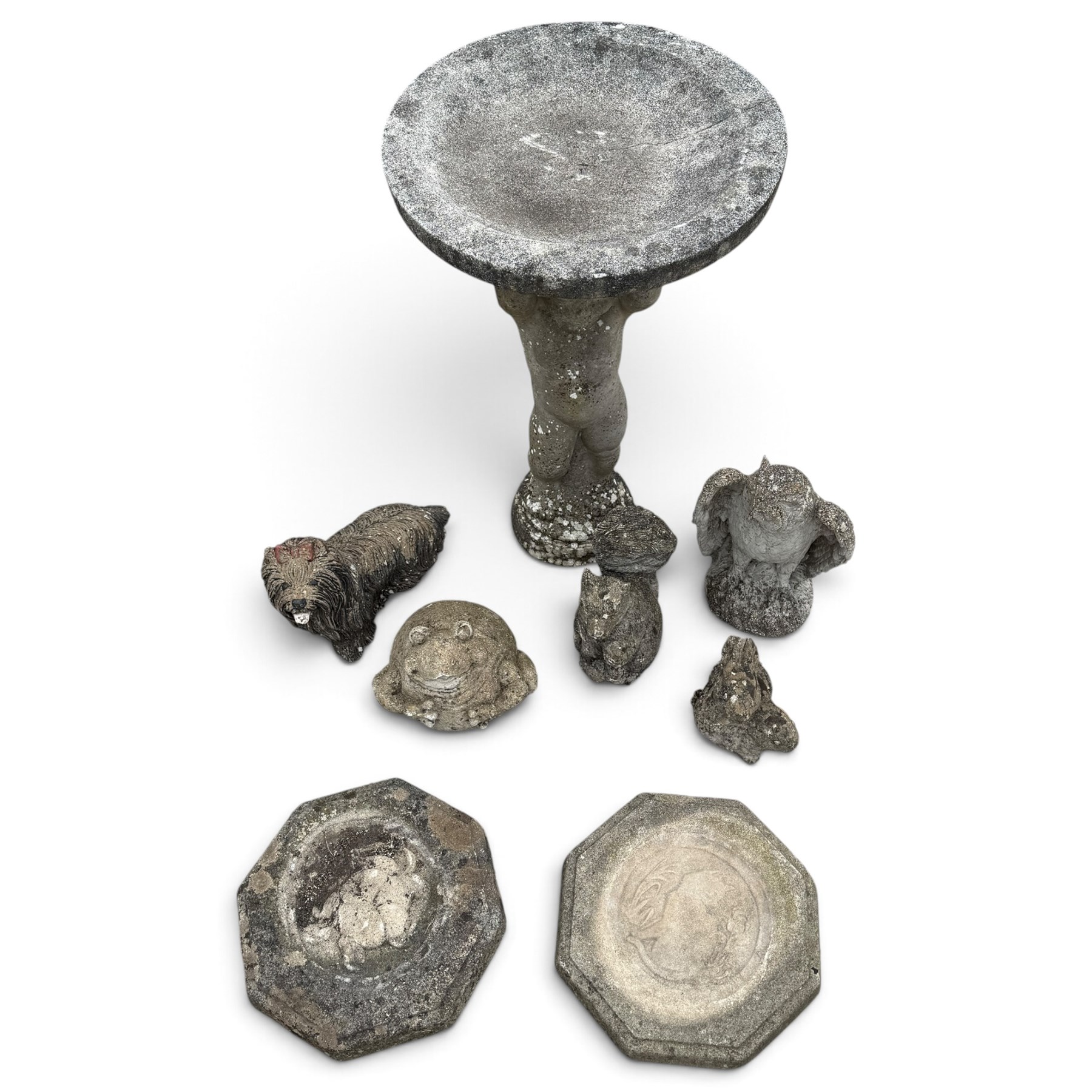 Assorted cast stone garden ornaments, comprising putto bird bath (W43cm H72cm), owl, dog, frog, rabbit and two squirrel figures, with two octagonal relief-moulded stepping stones, one decorated with central cat motif
