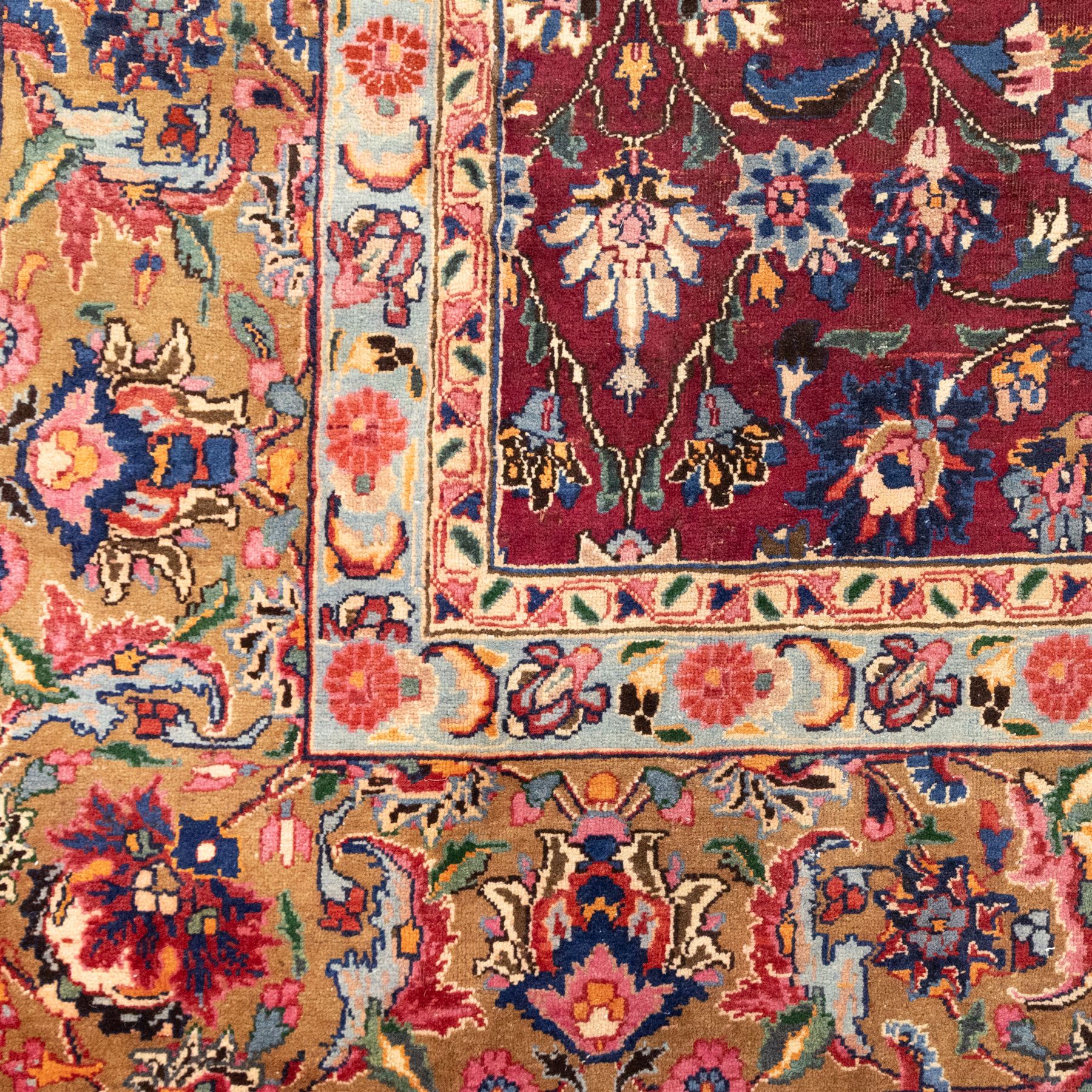 North East Persian Meshed hand-knotted carpet, rich red all-over field of finely decorated with dense scrolling floral sprays and palmettes and flowering vines, enclosed by a broad border in soft pastel tones, flanked by multiple guard borders, with cotton fringe ends  