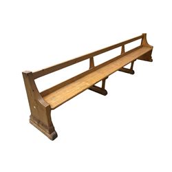 Early 20th century ecclesiastical pine bench or church pew, raised on chamfered supports with sledge feet