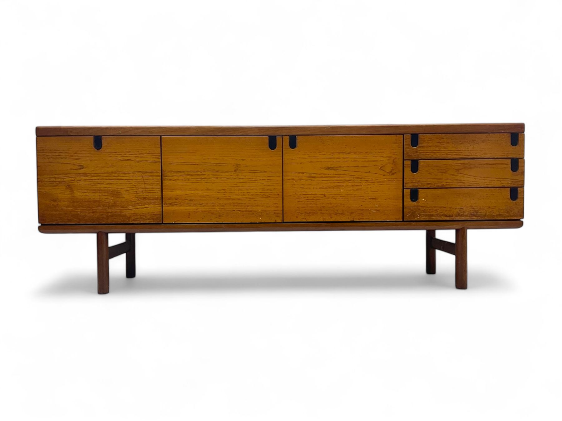 White & Newton - mid-20th century teak sideboard, rectangular top with raised back over fall-front storage compartment, double cupboard and three drawers, raised on cylindrical supports