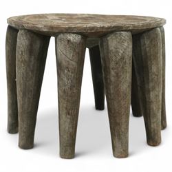 African Nupe carved tribal stool, the rounded top with repeating incised decoration and rope-edge border, supported by ten tapered legs D37cm