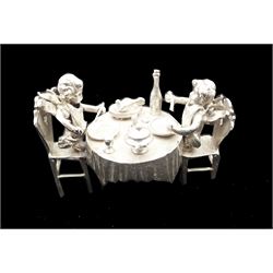 Early 20th century German Hanau silver miniature, modelled as two putti feasting at a dining table laden with food and drink, with Hanau marks for Neresheimer & Sohne, and hallmarked B Muller & Son, Chester import 1900, H3.5cm, approximate weight 1.26 ozt (39.2 grams)