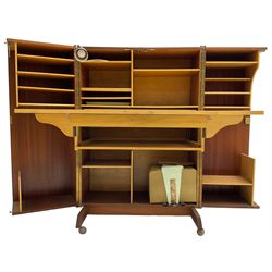 Mummenthaler & Meier - mid-20th century circa. 1960s teak 'Magic Box' folding desk cabinet, the cabinet opens to reveal shelves, writing desk, document holders and lamp, on castors