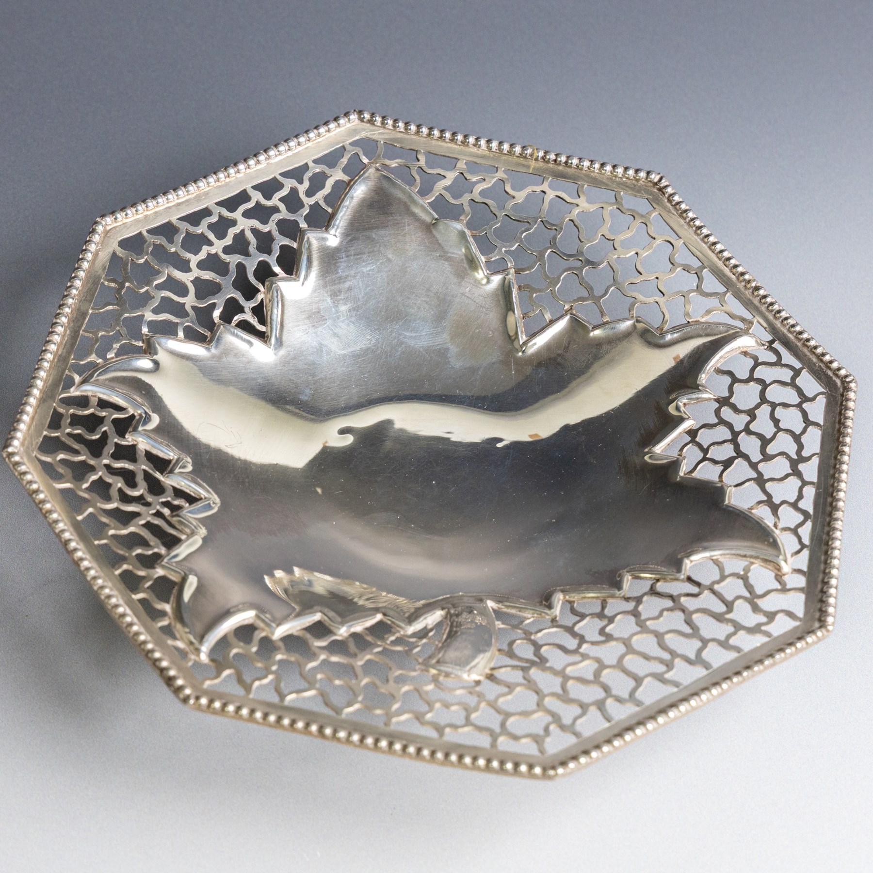 Indian silver dish, of octagonal form with central leaf decoration and pierced sides, upon three feet, W19cm