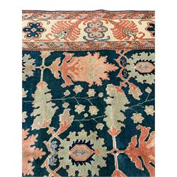 Persian emerald green ground rug, the field decorated with large stylised plant motifs, ivory ground border with repeating leaf motifs, the guards decorated with trailing branch and flowerhead motifs