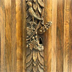 Late 17th century Flemish/Dutch rosewood and oak ‘Zeeuwse Kast’ or cupboard, projecting cornice carved with three putti masks, the uprights carved with lion masks over ribbons, flower heads and foliage, enclosed by four geometric panelled doors, lower central upright carved with flower head over foliate ribbon with bird among foliage, the escutcheon hidden by swivel berry carved cover, interior fitted with shelves, two drawers and shallow hinged cupboard, on two large turned and ebonised feet, circa 1680