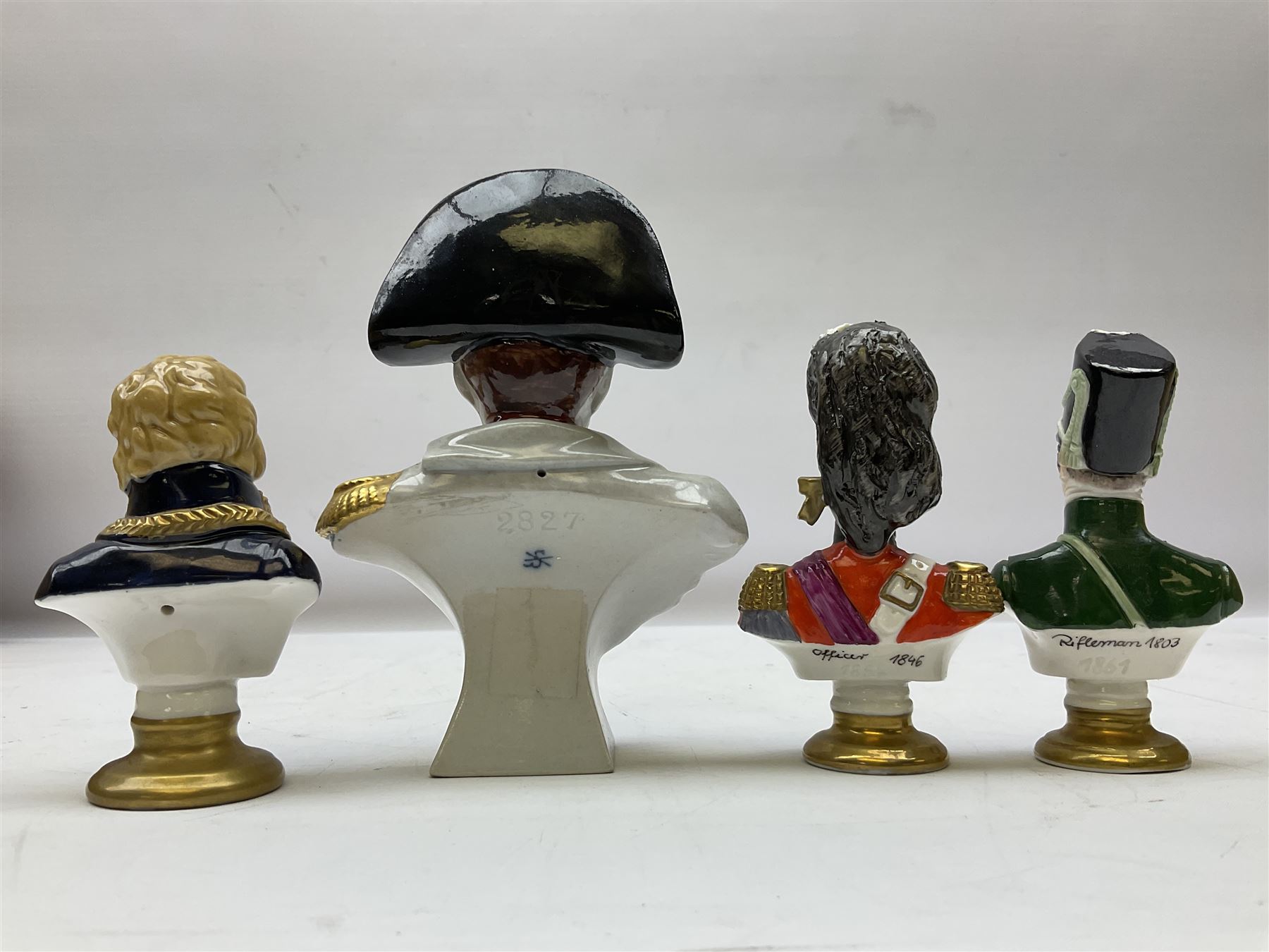 Group of Napoleonic busts comprising ‎Rudolf Kämmer Volkstedt examples of General Jean Lannes, 1st Duc de Montebello and Scottish Highland Infantry soldier and Rifleman 1803, all with blue crowned K marks beneath, and a bust of Napoleon raised upon square plinth, tallest H12cm