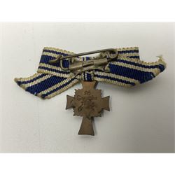 Four German awards - pre-WW2 two-position button hole ribbon for 1914 Iron Cross; WW1 wound badge open back cut-out version with silvered finish; miniature version Mother's Cross with ribbon bow; and The Eastern Medal, officially the Winter Battle in the East 1941–42 Medal (4)