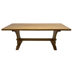 Medium oak rectangular dining table, raised on shaped end supports united by pegged stretcher, on sledge feet