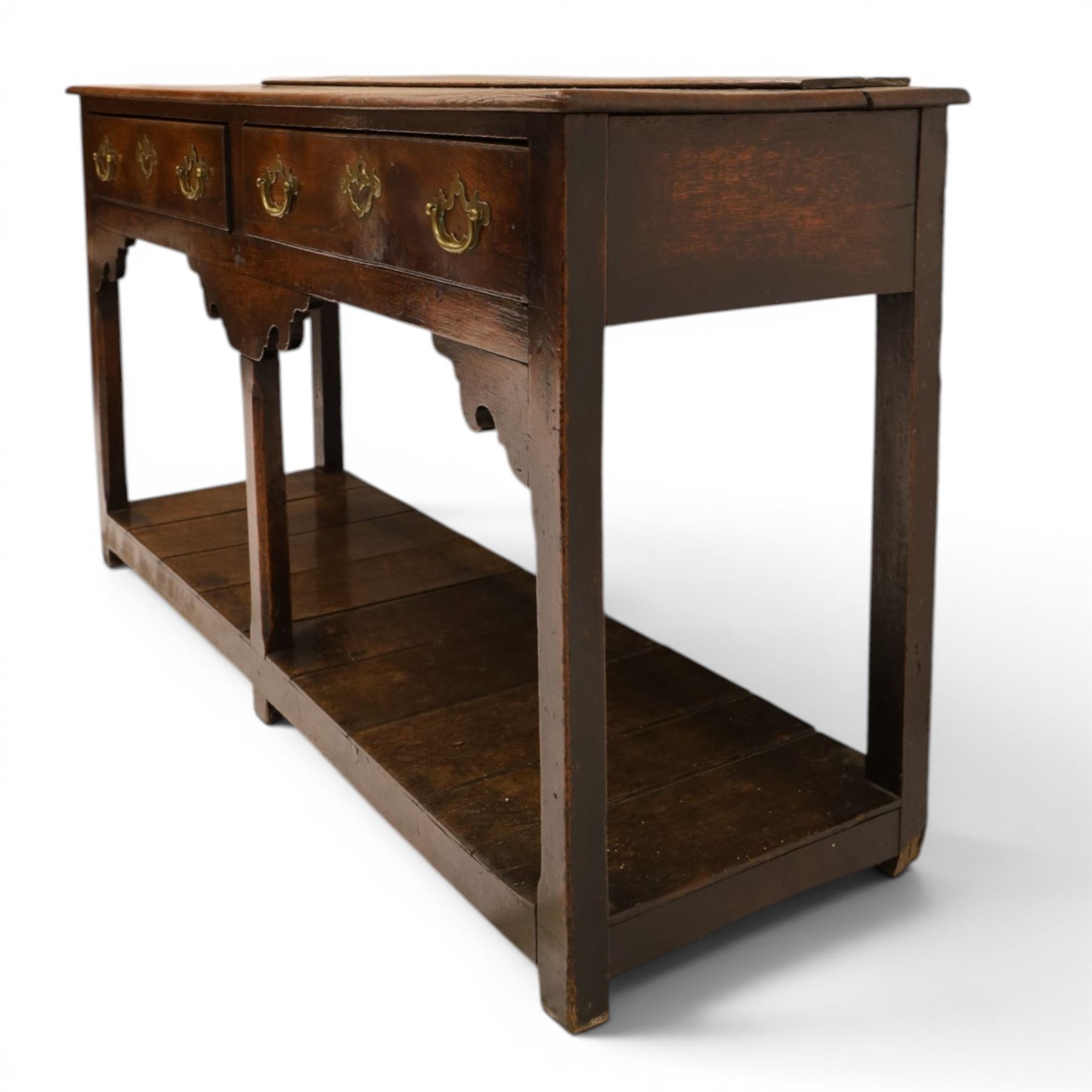 George III oak dresser base, rectangular top with moulded edge, fitted with two drawers over shaped spandrels, raised on square chamfered supports united by undertier, on stile feet