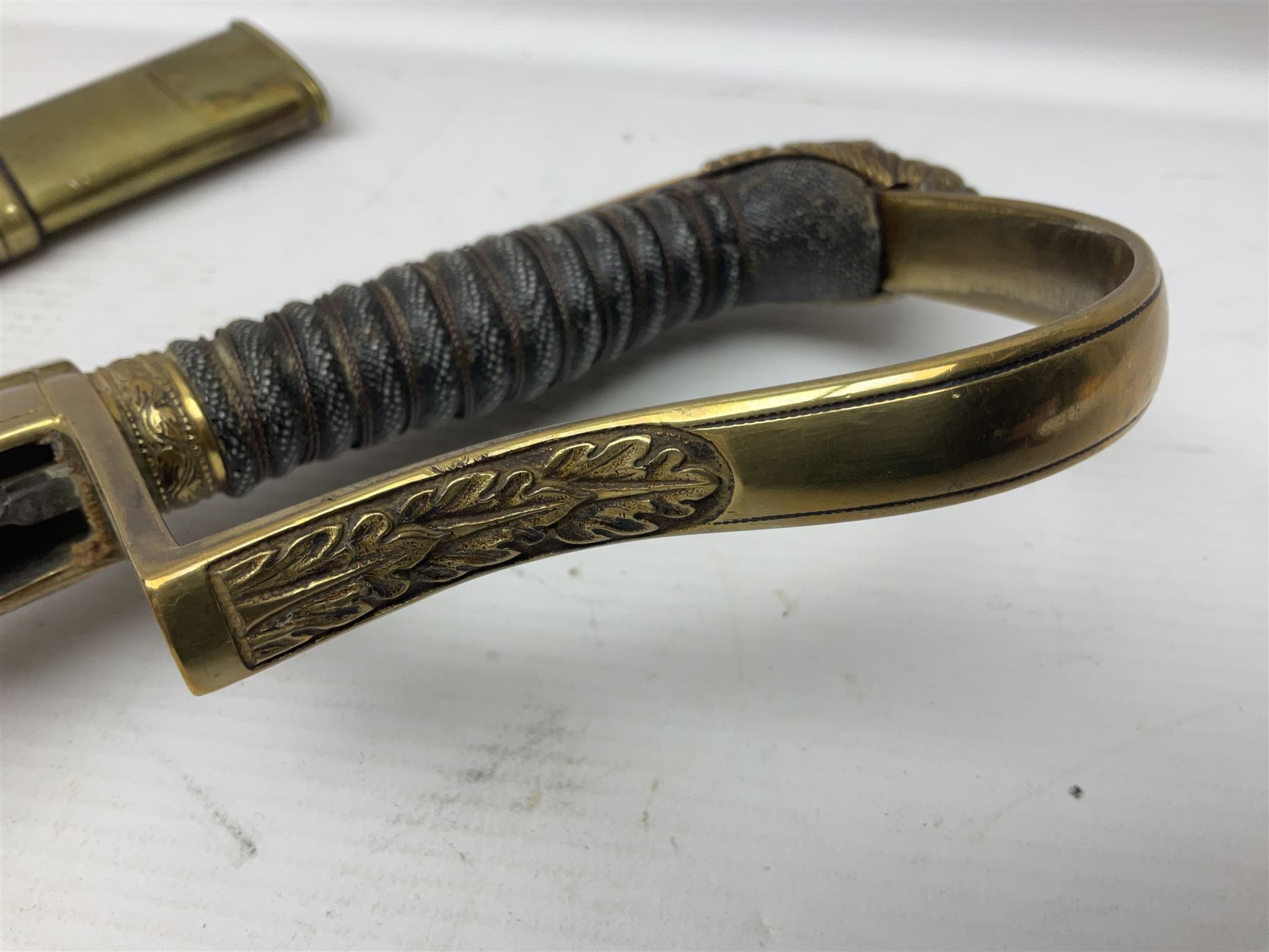 German Saxon 1st Empire Light Cavalry officer's sword c1820s, the 79cm clipped curving blade engraved with the crest of Hanover and various battle trophies with traces of blueing and gilding, brass hilt with knucklebow, foliate square langets, ornate downswept quillon, wire-bound fish skin grip with lion's head pommel; in brass scabbard with two suspension rings L95cm overall