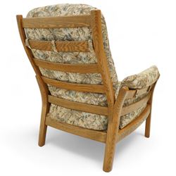 Ercol - golden elm 'Saville' armchair and matching footstool, elm frames with curved back supports and slatted sides, removable cushions upholstered in floral tapestry fabric, footstool (H 39cm, W 59cm)