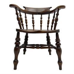 Early 20th century elm and beech smoker's bow elbow chair, shaped back and arms with scrolled terminals, on a series of turned spindle supports, dished seat on turned supports joined by double H stretcher