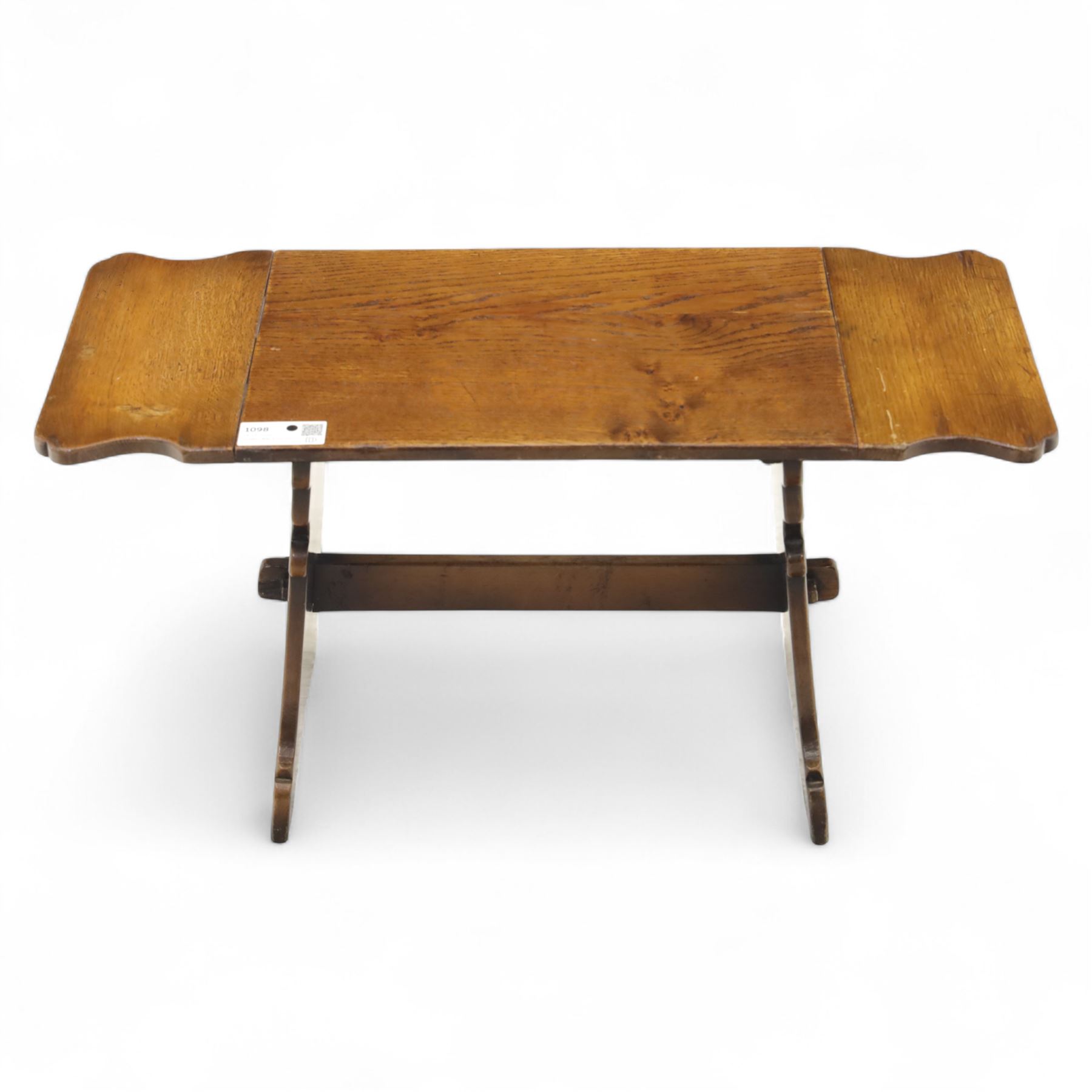Early 20th century oak drop leaf cottage table, rectangular top with twin hinged leaves, on shaped trestle end supports united by central stretcher