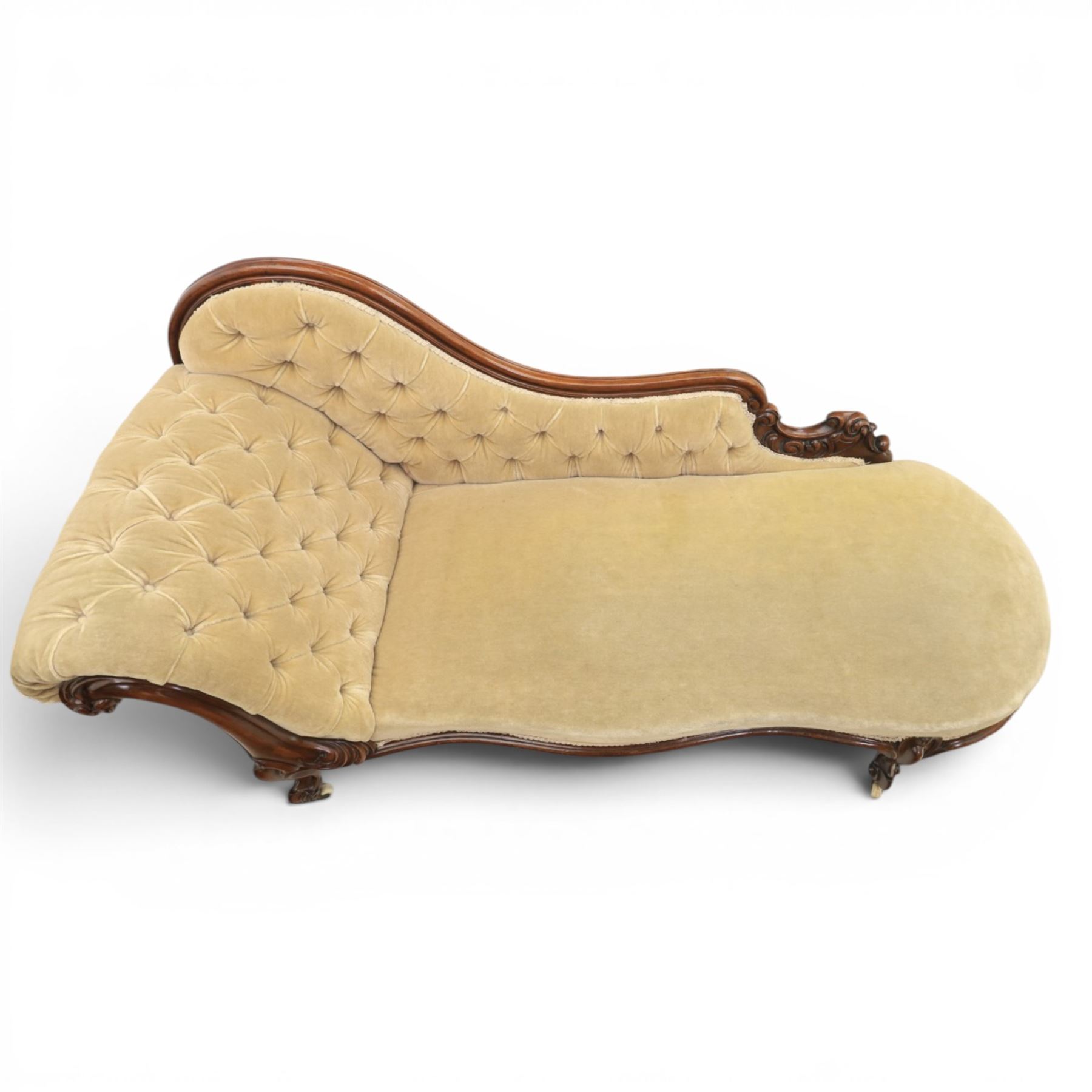 Victorian mahogany chaise lounge, scrolled back rest with deep buttoned back, upholstered in beige velvet, raised on a carved frame raised on cabriole supports terminating in castors 