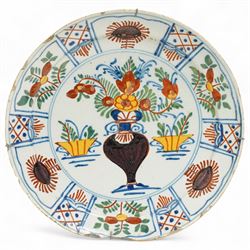 Pair of 18th century English Delft tin glazed plates, of circular form, decorated with stylised flowers in red and yellow, within a border of traditional repeating patterns of foliage and cross-hatching, bearing blue marks to base, D23cm