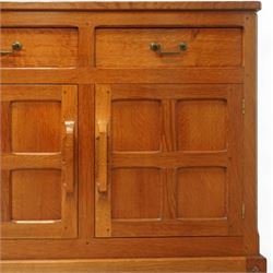 Seahorseman by Shaw & Riley - Yorkshire oak Welsh dresser, the dresser rack of rectilinear form with plain frieze and projecting moulded edge above two shelves with central shallow groove, the base section fitted with four drawers and a fitted cutlery drawer containing cutlery, above four panelled cupboard doors with geometric mouldings and carved sculpted handles, interior with single shelf and sides with geometric mouldings raised on a shallow plinth base with shaped bracket feet, with signature Seahorse carving from the workshop from the workshop of A. Shaw & Riley Ltd, Hessay