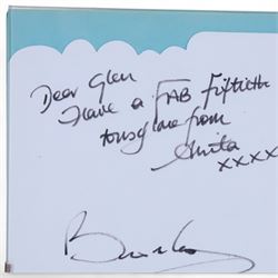 Birthday card and postcard, each signed by Brian May and Anita Dobson, with a personalised Anita Dobson compliment slip dated 2008, in glass frame