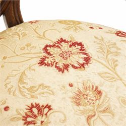 Victorian Ladies and Gentleman's carved walnut drawing room chairs, each with shaped cresting rail carved with scrolls and flowerheads, upholstered in pale gold floral fabric, raised on foliate-carved cabriole supports terminating to brass and ceramic castors