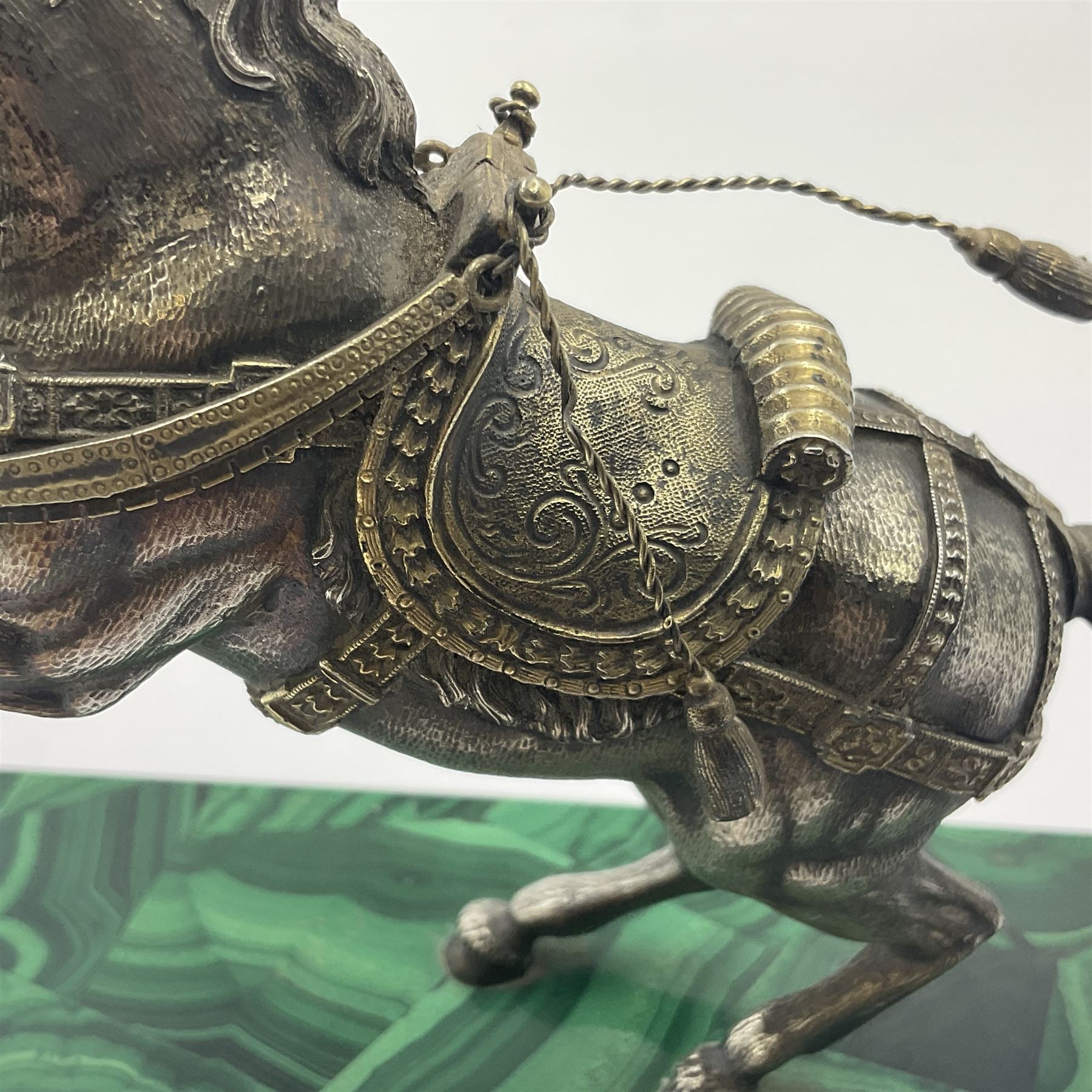 Modern silver model of a rearing horse, with ornate parcel gilt saddle and bridle, mounted upon a rectangular base, decorated with malachite panels to each side and upon four gilt bun feet, horse stamped 925, overall H14.5cm