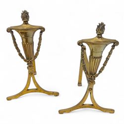 20th century fire side items, two brass fire fenders, one of pierced gallery design with urn finials and turned supports, the other with scroll pierced ends and plain moulded rail (H 26cm, W 128cm, D 32cm) (H 23cm, W 134cm, D 21cm) and two brass fire dogs (H 34cm, W 20cm, D 17cm)
