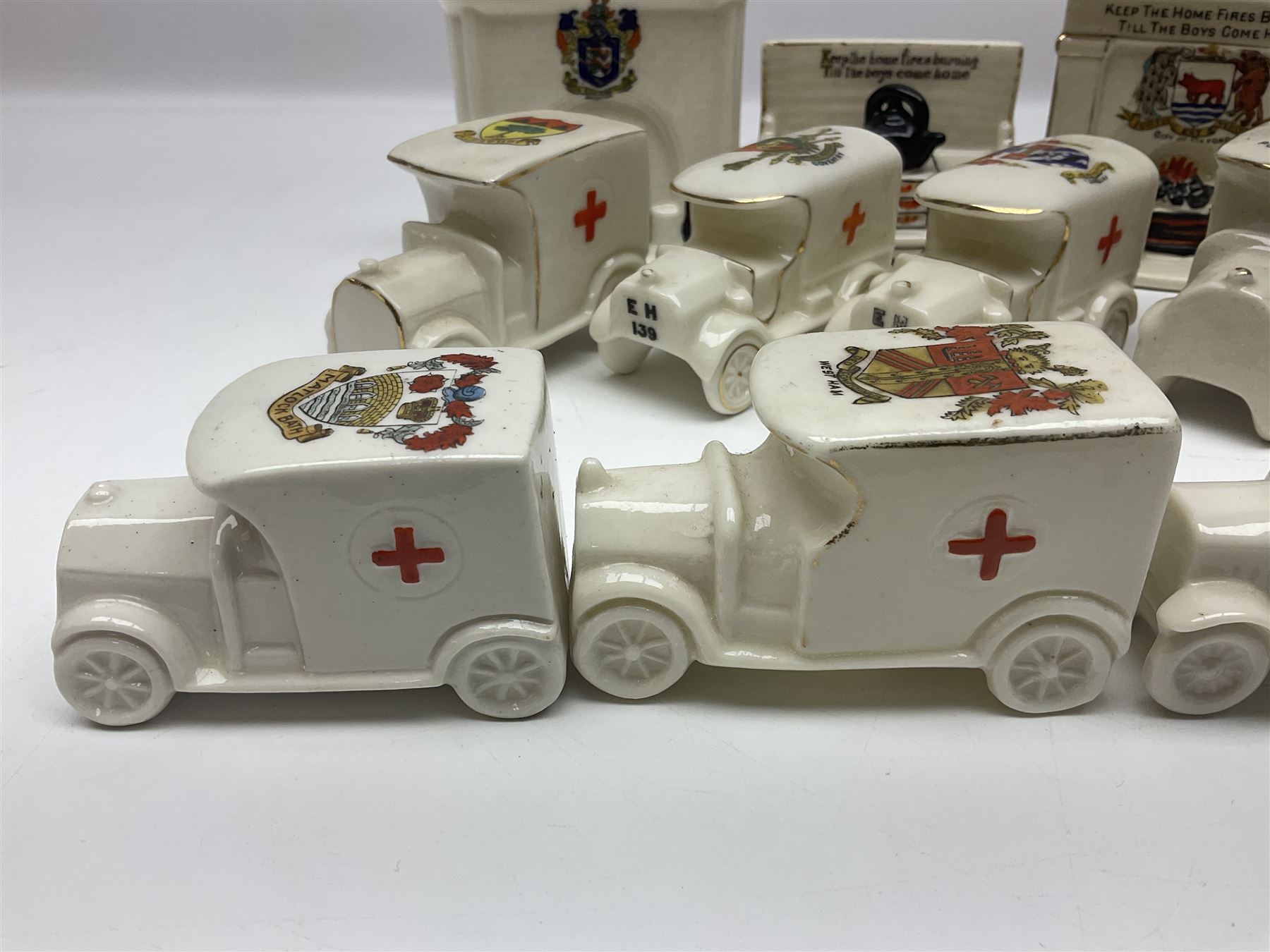 Ten WW1 crested china military models comprising seven field ambulances and three 'Home Fires Burning' fire-surrounds/range; various makers including Willow Art, Arcadian China, Grafton China, Savoy China, Carlton China etc; various crests including Devon, Aldershot, Portsmouth, West Ham, Coventry, Oxford, Hastings, Brighton etc (10)