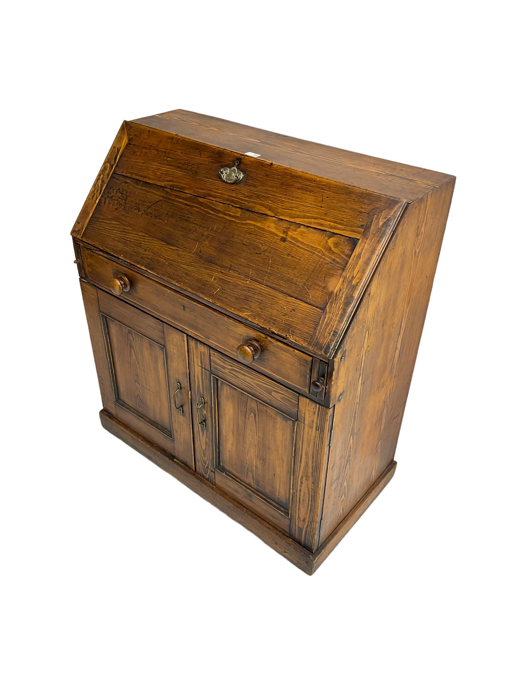 19th century waxed pine bureau, the fall front opening to reveal fitted interior with two drawers and five pigeonholes, base with single drawer over two panelled cupboard doors, on plinth base