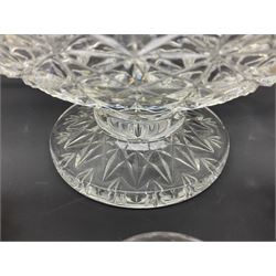 Large Stuart crystal pedestal punch bowl, of circular form, the rim with engraved floral decoration, upon spreading circular foot with radial cut decoration, with seven matching Stuart crystal drinking glasses, each with a C handle, each acid signed beneath, bowl H20cm
