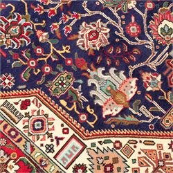 North West Persian carpet, the indigo field centred by a large terracotta and ivory medallion with matching pendants, decorated throughout with stylised palmettes, flowerheads and branching foliage, ivory geometric floral spandrels, enclosed by a red palmette border and narrow patterned guard bands