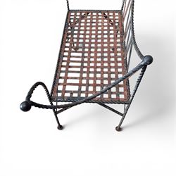 Victorian design wrought iron garden bench, with asymmetrical rope-twist frame, arched back and sides over out-swept arm terminals with ball finials, flanking a lattice seat, in antique black-painted weathered finish