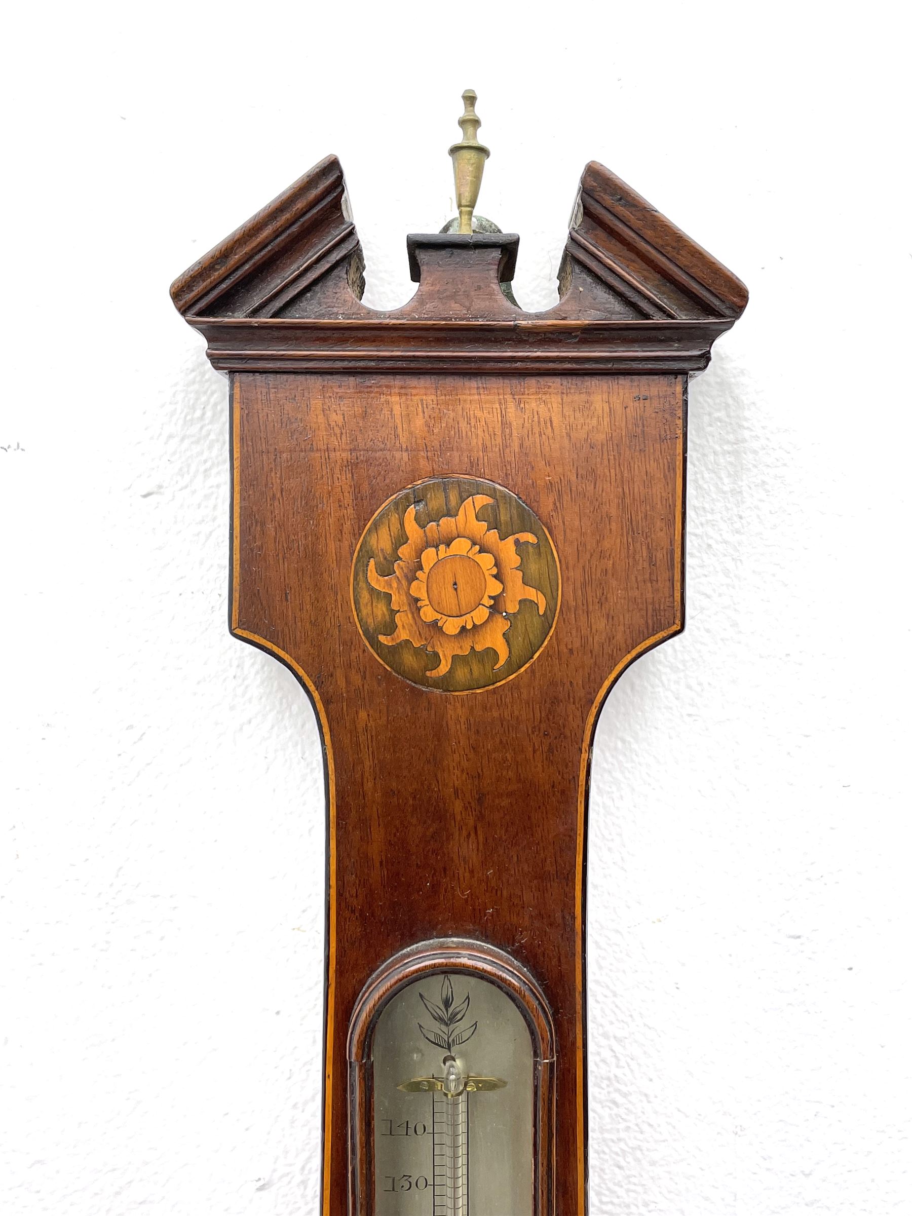 Early 19th century William IV mercury wheel barometer with a rosette inlaid broken pediment and correspondingly inlaid round base, mahogany veneered case with inlaid oval conch shell paterae and satinwood stringing to the edge, with an arched thermometer box and spirit thermometer measuring degrees Fahrenheit from 20 to 120, eight-inch silvered register reading barometric pressure in inches from 28  to 31, with predictions in Roman upper and lower case and script, dial inscribed “A Tagliabue,24 Grenville Street, Luther Lane, London”, with a steel indicating hand, brass recording hand and cast brass bezel.