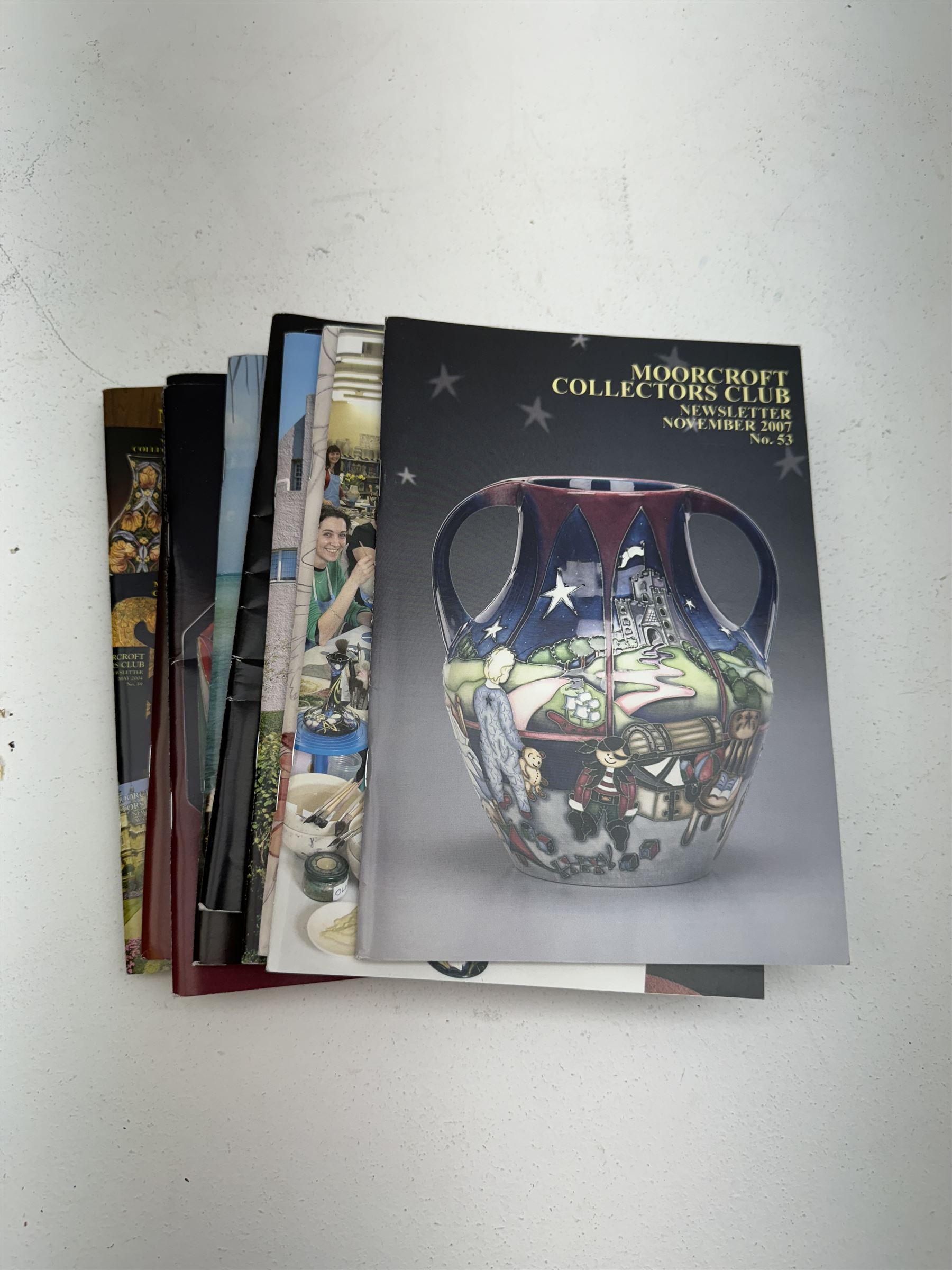 Three Moorcroft reference books, comprising Winds of Change, The Phoenix Years and A New Dawn, together with a collection of Moorcroft magazines 