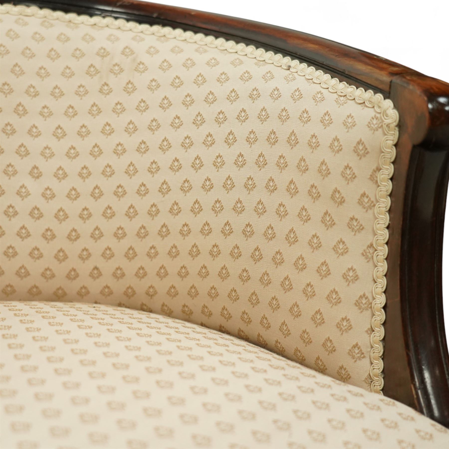 Victorian mahogany upholstered settee, the shaped back with pierced foliate carved cresting, upholstered in cream patterned fabric with serpentine seat, on cabriole front legs with brass castors