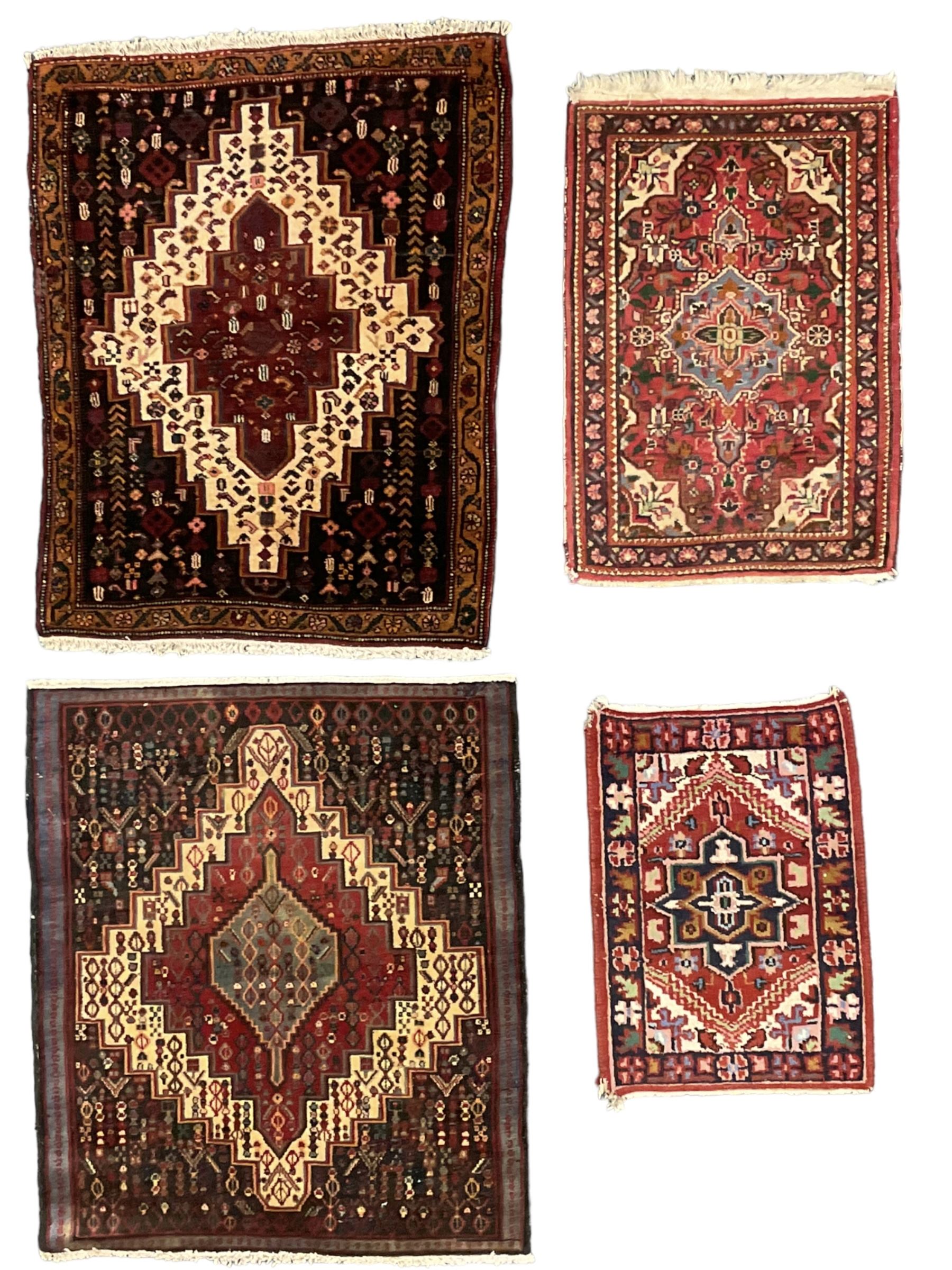 Small Hamadan dark indigo ground rug, central ivory and maroon lozenge with geometric decoration, guarded border with repeating stylised plant motifs, together with three others (4)