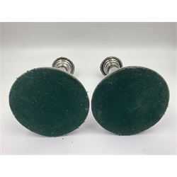 Four George III silver candlesticks, each upon knopped stem and weighted circular stepped foot, the foot and removable sconce repousse decorated with a band of flower heads, hallmarked to sconce and foot Thomas & John Settle, Sheffield 1820, H17.5cm