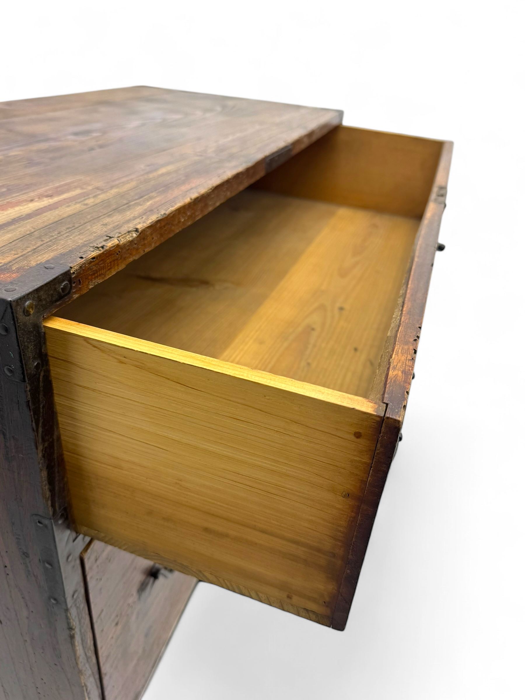 Late 19th century Japanese tansu chest, crafted with a cedar frame and cypress wood panels, original iron fittings throughout, comprising a single long drawer above smaller drawer and hinged cupboard door enclosing two smaller internal drawers and storage compartment, mounted on a bespoke black metal stand