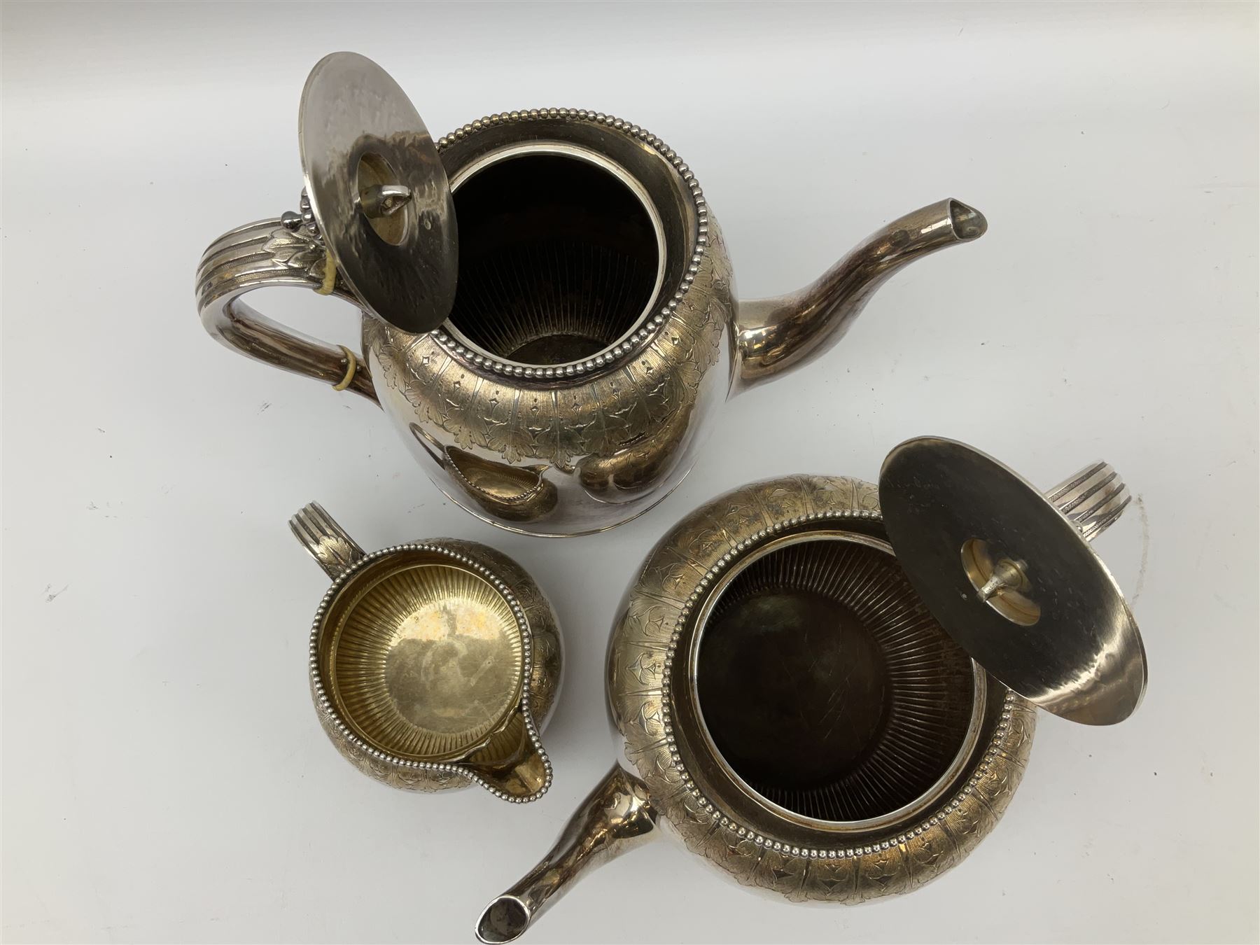 Elkington & Co. silver plate tea set, consisting teapot, coffee pot and milk jug, with engraved foliate decoration and a beaded edge