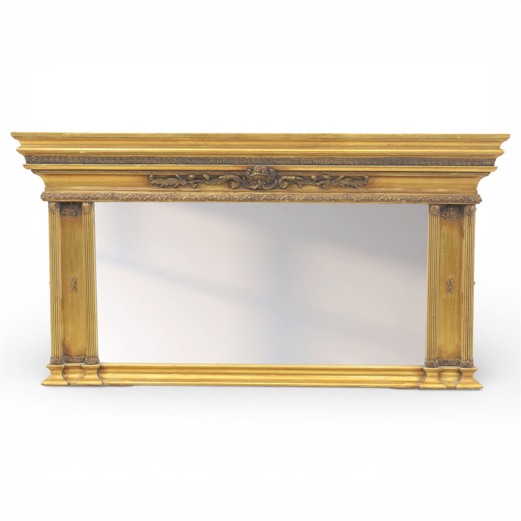 Early 20th century gilt over mantel mirror, the rectangular plate within stepped and moulded frame with central applied foliate ornament and fluted side uprights
