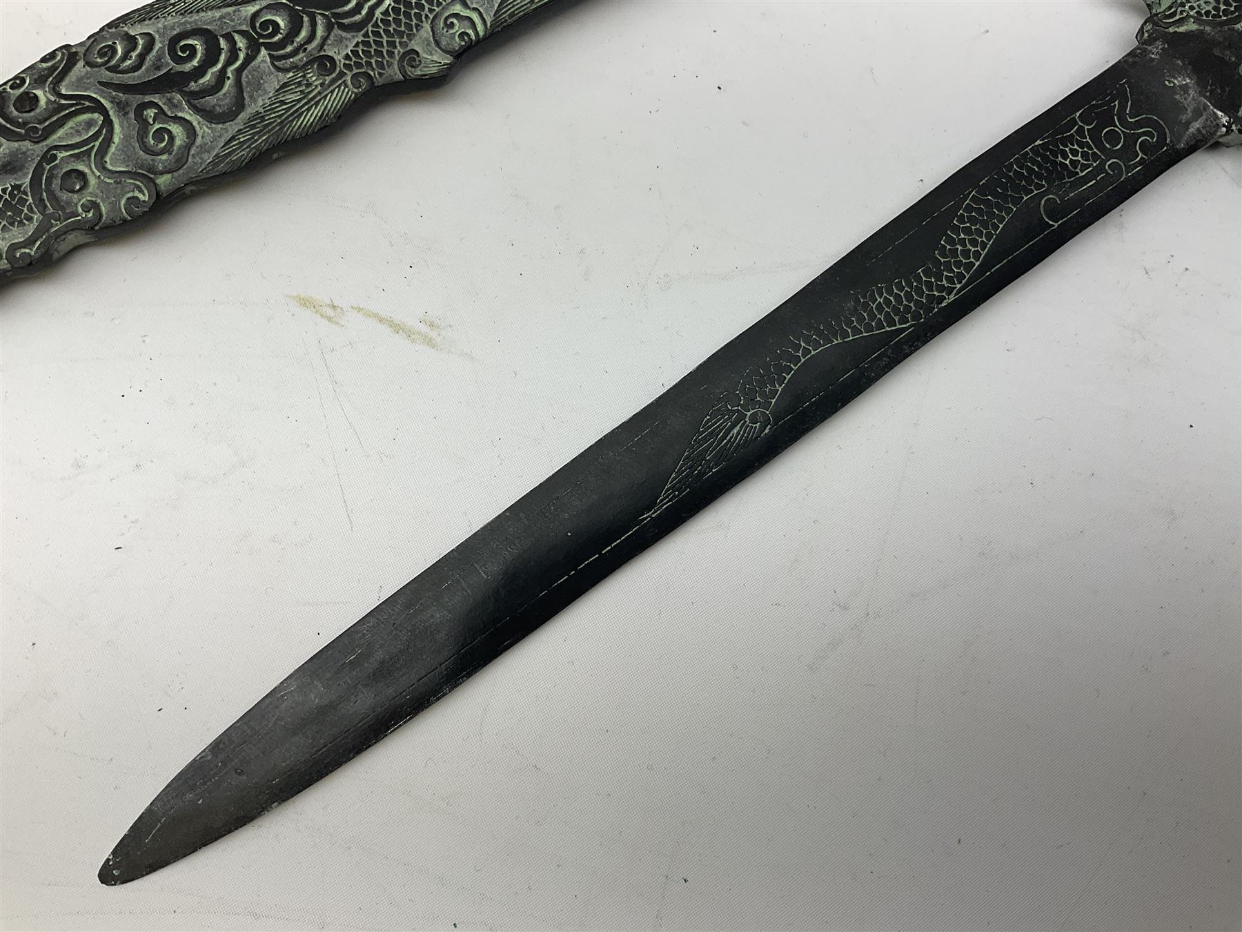 Patinated 'bronze' fantasy dagger, the 26cm blade, hilt and scabbard cast with dragons L50cm overall; hand forged iron spearhead L29.5cm; and a stiletto blade (3)
