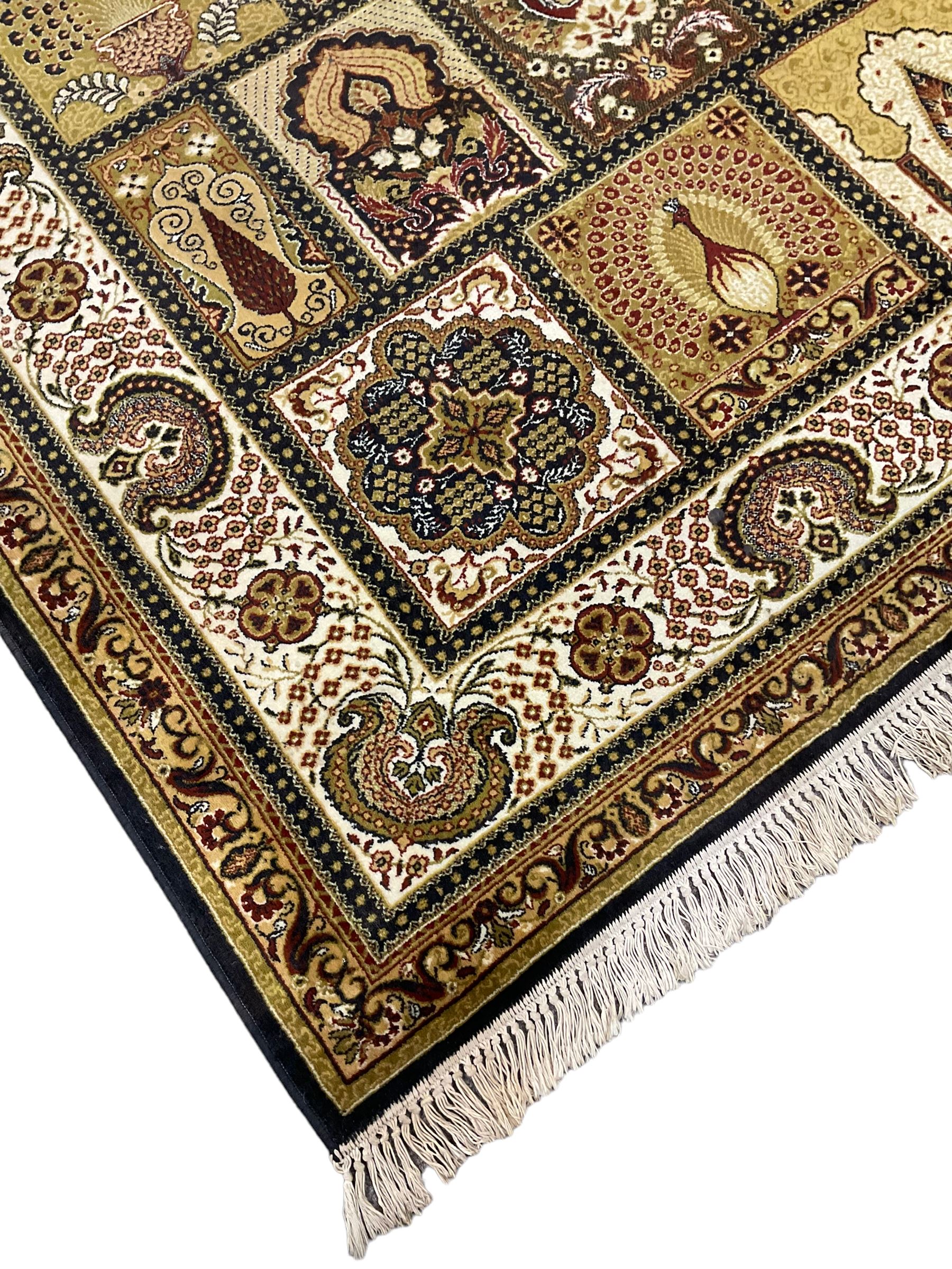 Persian design carpet, the field with various size tiles decorated with stylised plant motifs, floral urns and peacocks, the main border decorated with repeating foliate motifs and trailing flower heads