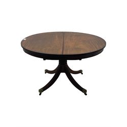 Regency design mahogany extending dining table, circular top with reeded edge and pull-out mechanism to accommodate additional leaf, raised on a carved central baluster column with acanthus detailing, supported by a quadruple reeded splay base terminating in brass caps and castors

