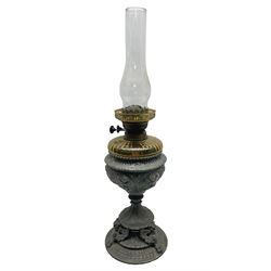 Victorian cast spelter oil lamp, decorated with cherubs and foliate scrolls, supporting a glass reservoir, burner and clear glass chimney, H62cm