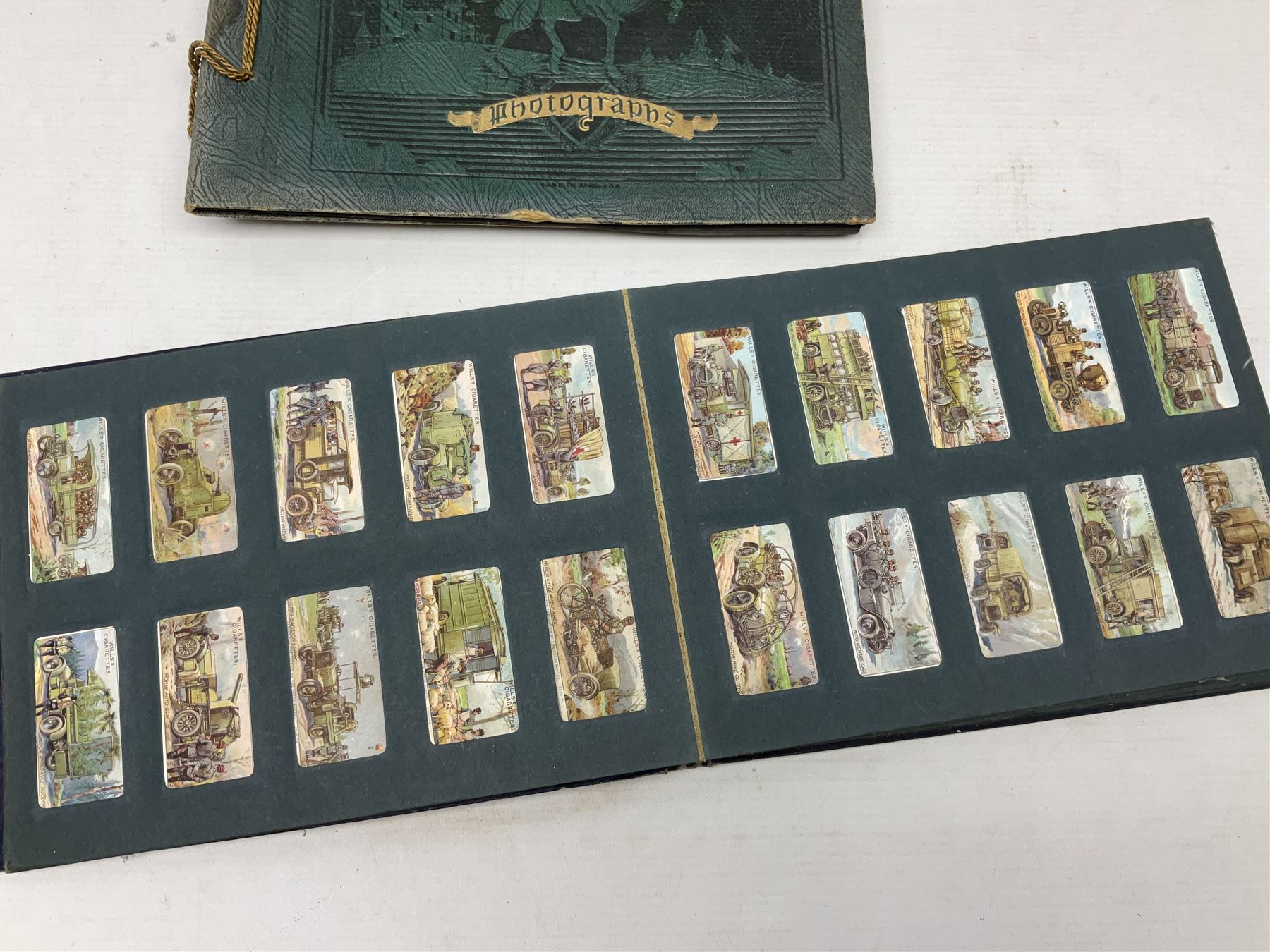 Three albums of cigarette cards including Wills Recruiting Posters, Military Motors and Allied Army Leaders, cricketers etc; another album containing a large quantity of laid-in cigarette cards; and an album of thirty-seven postcards of dogs by Mac (5)