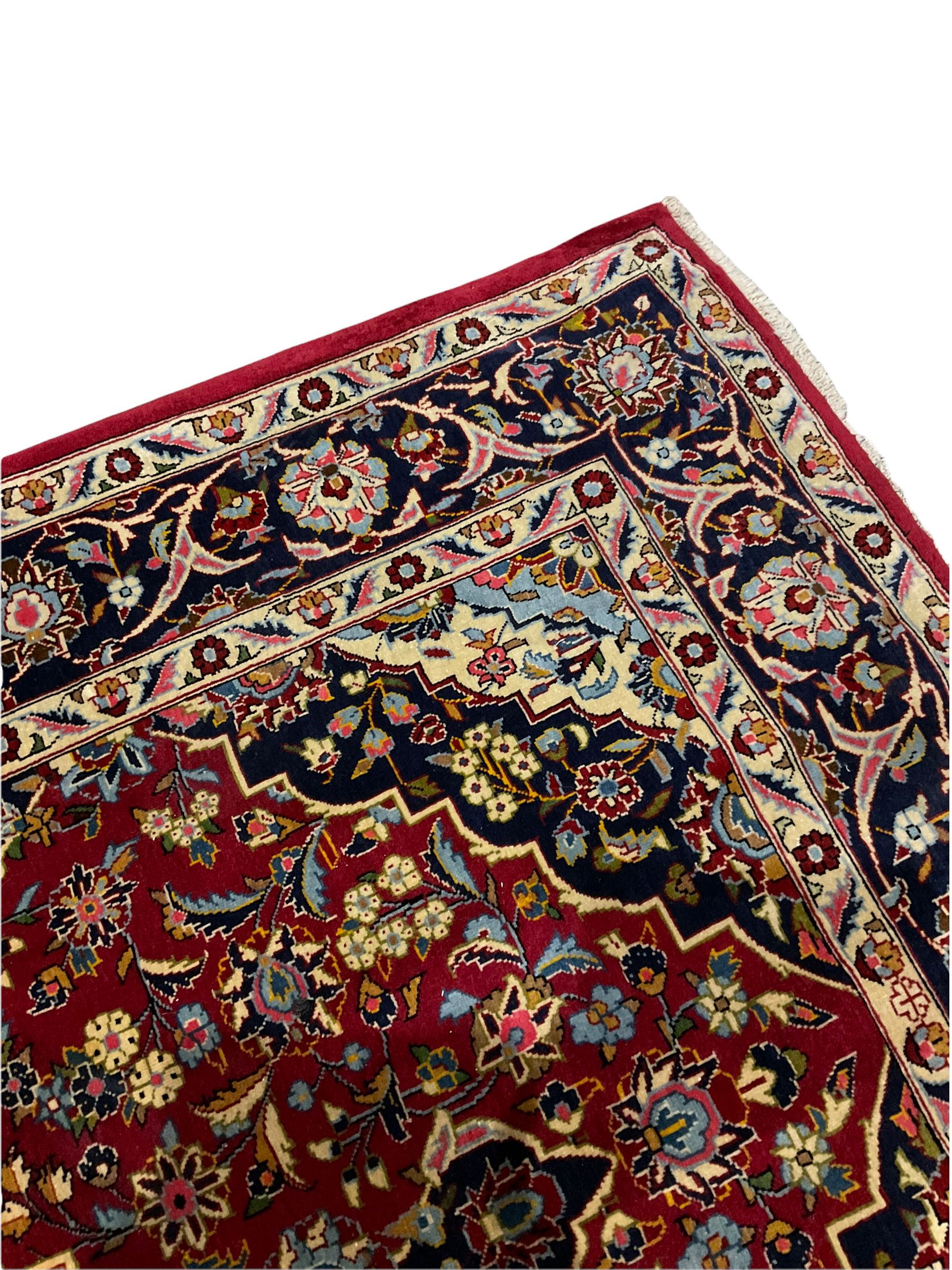 Persian red ground Kashan rug, decorated with flower and plant motifs