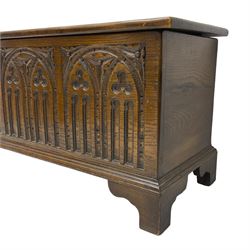 Mid-20th century oak blanket box, hinged lid over front carved with Gothic tracery work and flower heads, on bracket feet