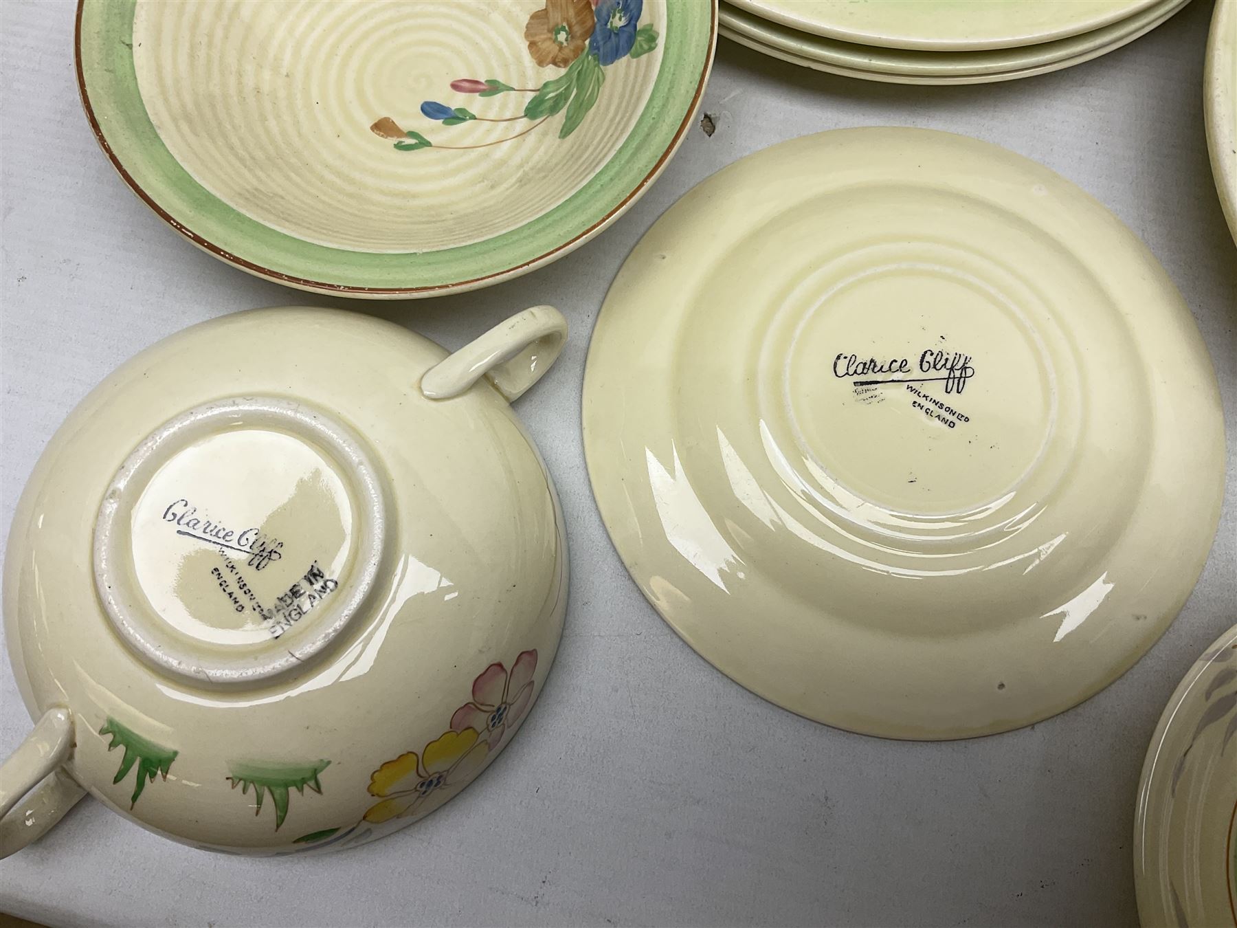 Clarice Cliff for Newport Pottery Corolla pattern tea and dinner wares, comprising triangular bowl, four side plates, two shallow bowls and teacup (a/f), together with a Clarice Cliff Wilkinson twin handled soup bowl and unassociated saucer both decorated with pink and yellow flowers, together with other mid century ceramics comprising Parrott and Company Coronet Ware, and Royal Staffordshire AJ. Wilkinson Ltd dinner wares